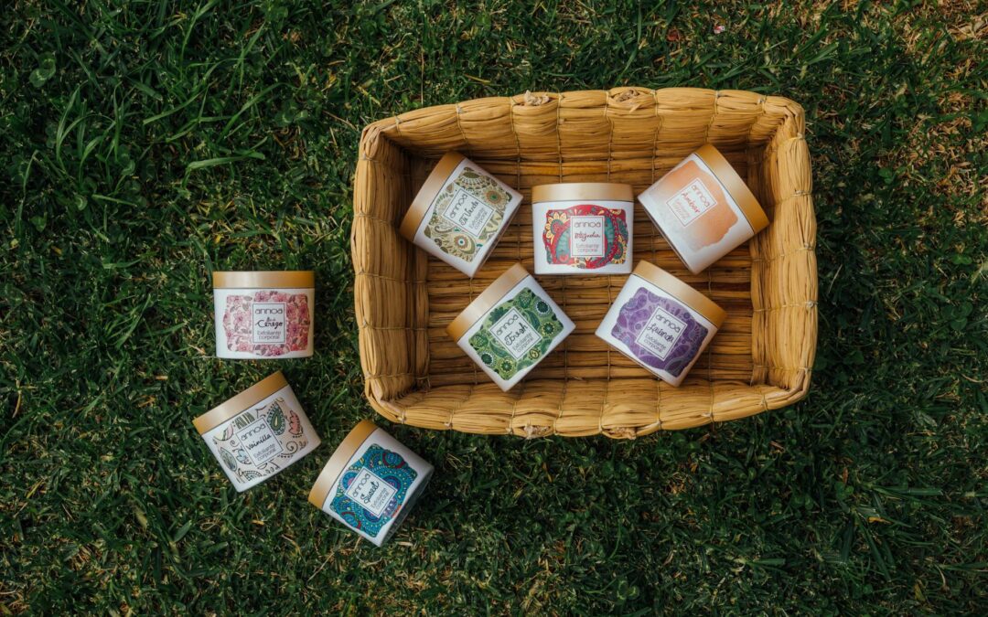 Top view of assorted herbal creams arranged in a wicker basket on grass, showcasing natural skincare products.
