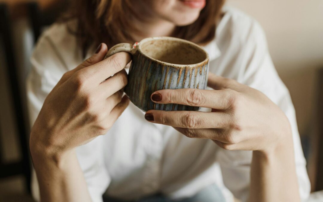 Enjoy a relaxing moment with a warm cup of coffee in a handmade mug, perfect for cozy mornings.