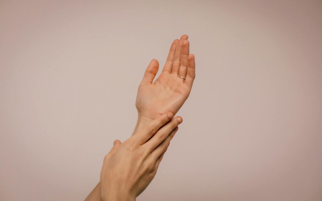 Close-up of hands gently caressing each other, symbolizing self-care and softness.