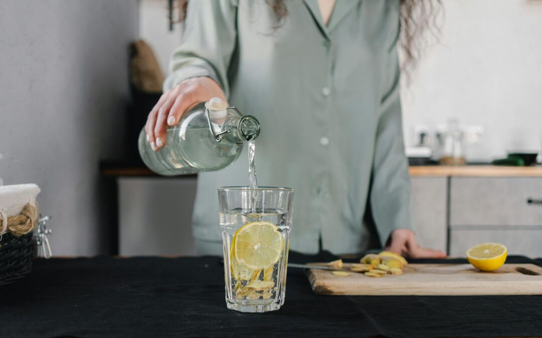 Woman pours water for lemon ginger infusion, promoting health and hydration.